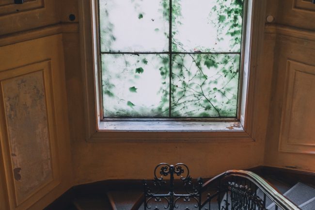 a beautiful old staircase and a window 