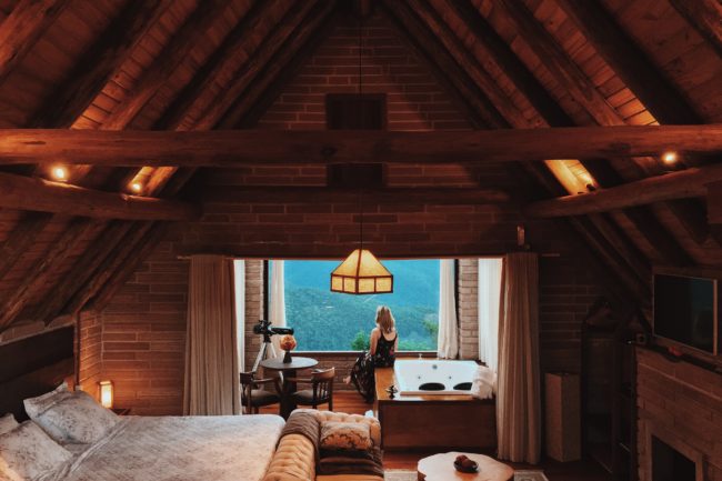 Woman in cozy attic space admiring the outdoors.