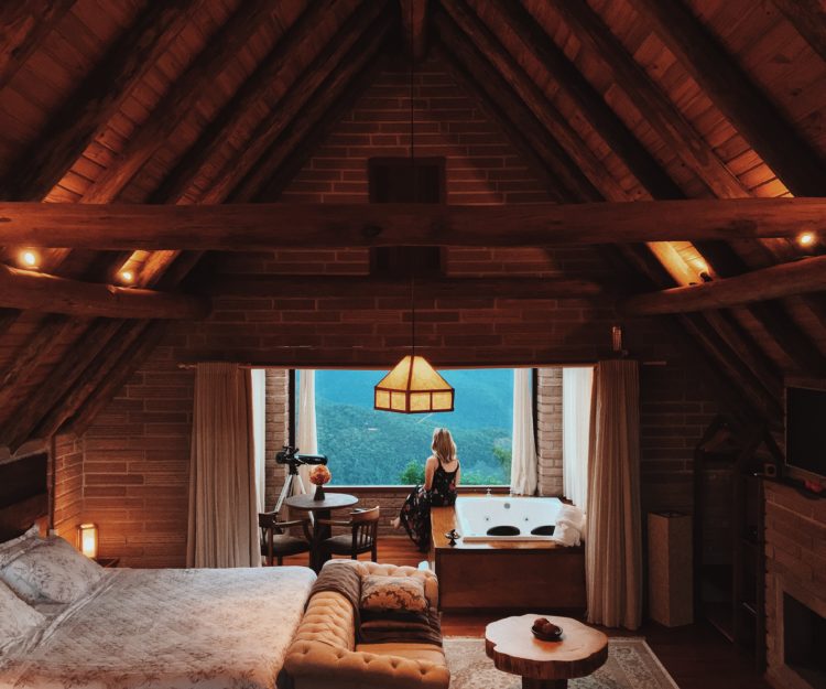 Woman in cozy attic space admiring the outdoors.